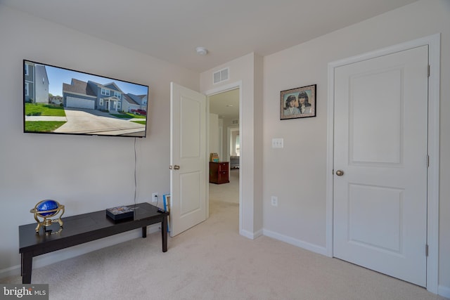 interior space featuring visible vents, baseboards, and light colored carpet