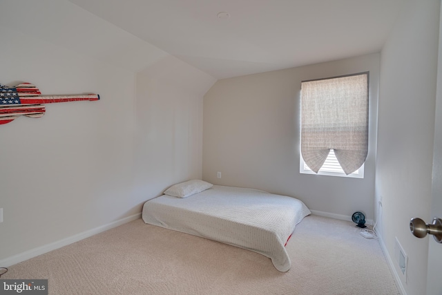 carpeted bedroom with baseboards, lofted ceiling, and visible vents