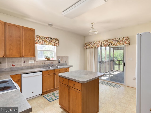 kitchen with plenty of natural light, a sink, light floors, and white appliances