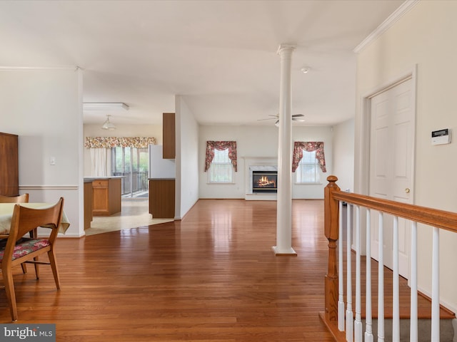 living area featuring baseboards, a glass covered fireplace, and wood finished floors