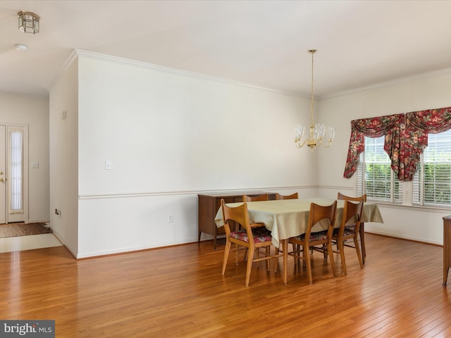 dining space with crown molding, baseboards, an inviting chandelier, and light wood finished floors