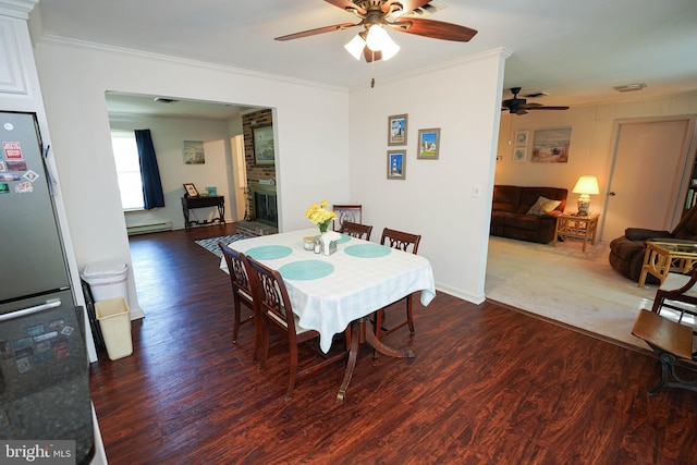 dining room with crown molding, wood finished floors, baseboards, a baseboard radiator, and a ceiling fan