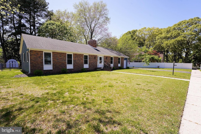 ranch-style house featuring brick siding, fence, a front yard, and a chimney