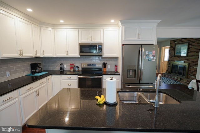 kitchen featuring a sink, tasteful backsplash, stainless steel appliances, and white cabinetry