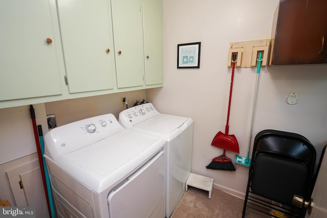 laundry area with cabinet space, baseboards, light colored carpet, and washing machine and dryer
