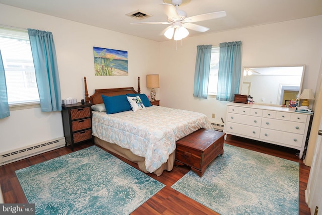 bedroom with visible vents, multiple windows, baseboard heating, and dark wood-type flooring