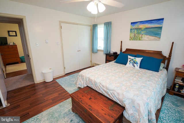 bedroom featuring a closet, wood finished floors, baseboards, a baseboard heating unit, and a ceiling fan