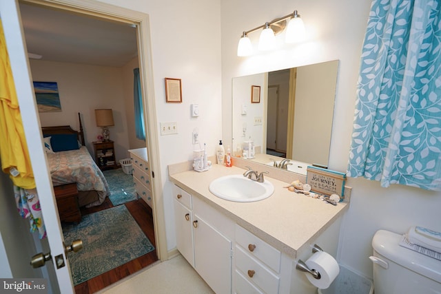 bathroom featuring toilet, ensuite bathroom, and vanity
