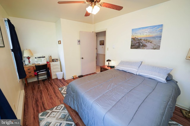 bedroom featuring ceiling fan, a baseboard heating unit, and wood finished floors