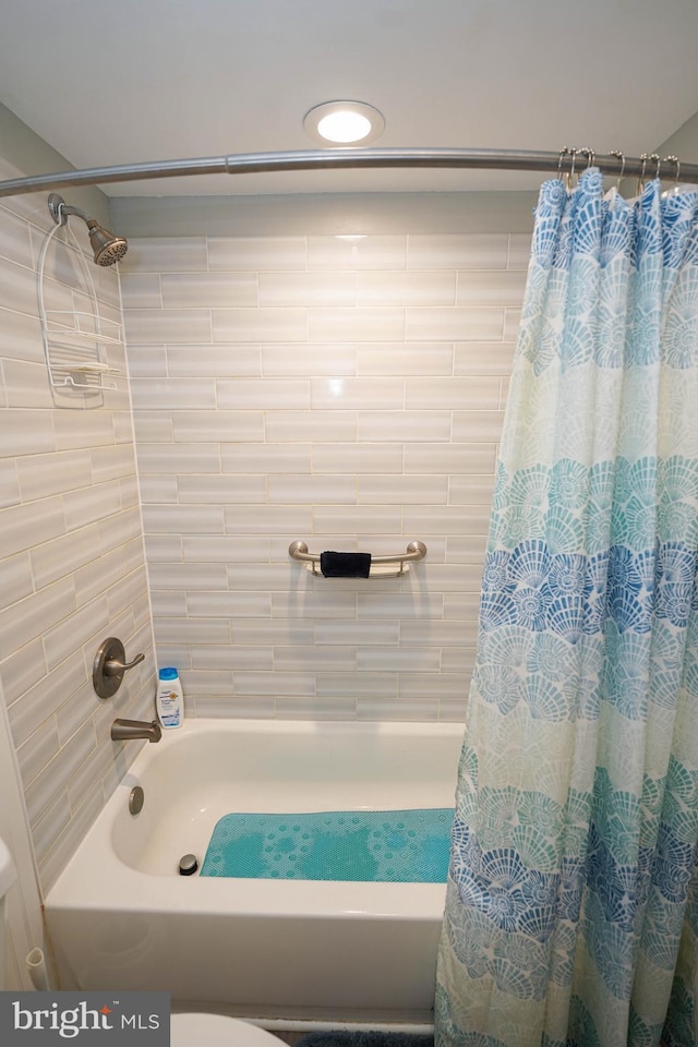 full bathroom featuring toilet and shower / bath combination with curtain