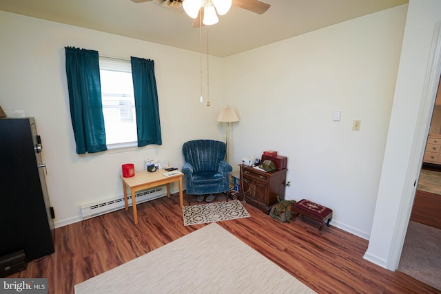 living area featuring baseboards, a baseboard radiator, a ceiling fan, and wood finished floors