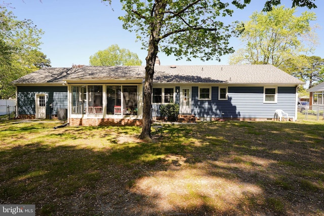 back of property featuring fence, a yard, a sunroom, and crawl space