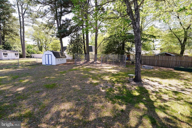 view of yard with an outdoor structure, a shed, and a fenced backyard