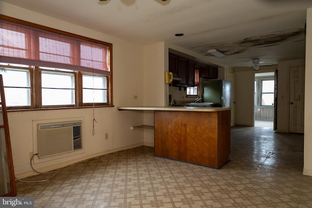 4398 S Bowers Rd, Milford, DE 19963 - kitchen featuring a peninsula, light floors, ceiling fan, light countertops, and a wall unit AC