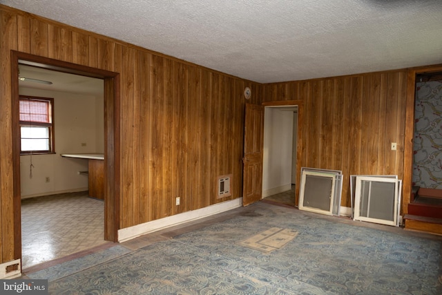 4398 S Bowers Rd, Milford, DE 19963 - unfurnished living room featuring a textured ceiling, tile patterned floors, and wooden walls