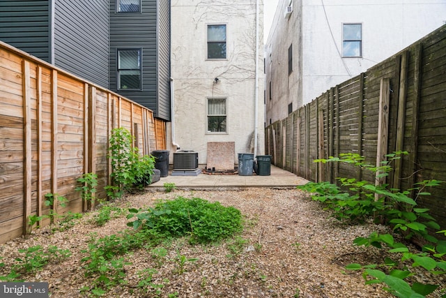 view of yard featuring a fenced backyard, a patio area, and central air condition unit