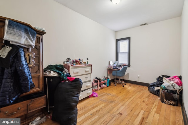 interior space with visible vents, baseboards, and hardwood / wood-style flooring