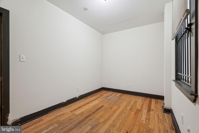 unfurnished room with light wood-style flooring and baseboards