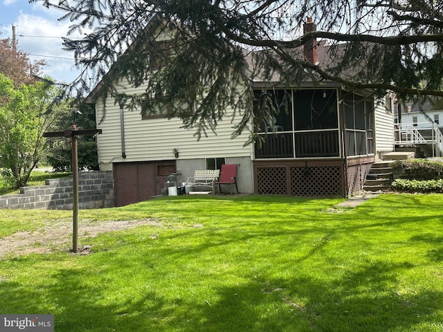 back of house with a yard and a sunroom