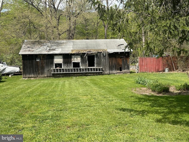 exterior space with a lawn, board and batten siding, and fence