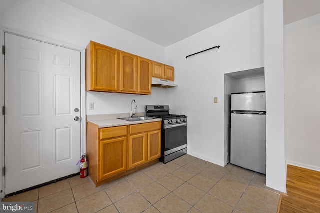 3800 Spring Garden St, Philadelphia, PA 19104 - kitchen featuring appliances with stainless steel finishes, a sink, light tile patterned floors, light countertops, and under cabinet range hood