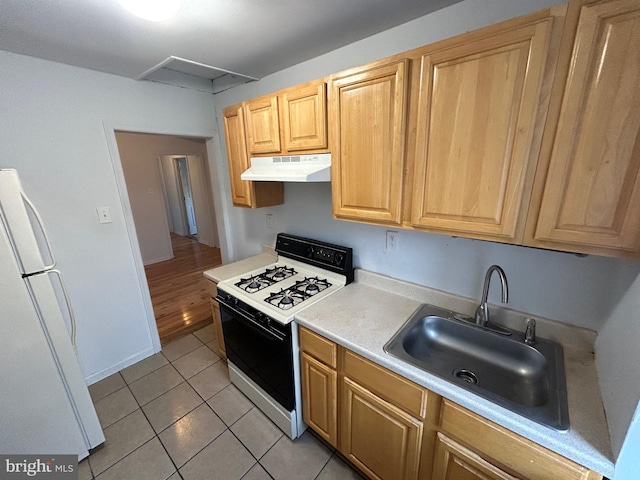 3800 Spring Garden St, Philadelphia, PA 19104 - kitchen featuring light tile patterned flooring, a sink, freestanding refrigerator, under cabinet range hood, and range with gas cooktop