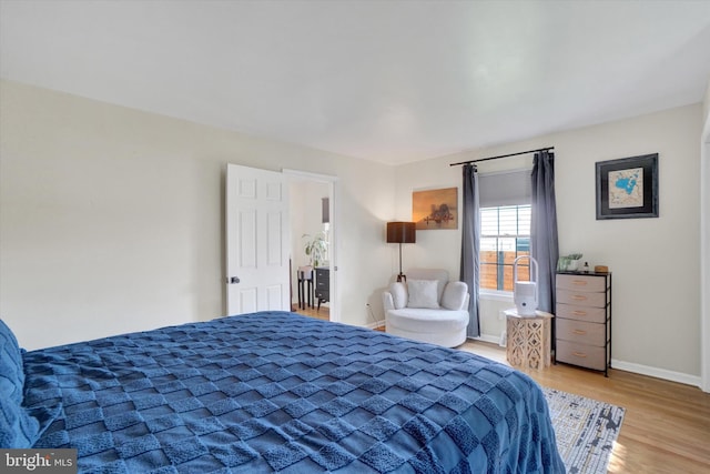 bedroom with baseboards and wood finished floors
