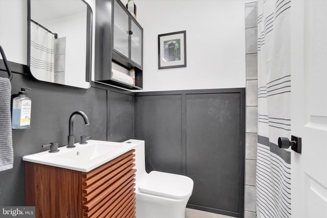 bathroom with vanity, a shower with shower curtain, and toilet