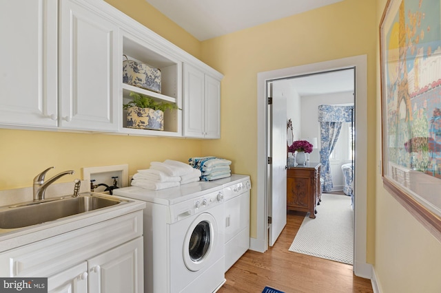 8620 Bozman Neavitt, Saint Michaels, MD 21663 - laundry area featuring cabinet space, a sink, baseboards, light wood-style floors, and separate washer and dryer