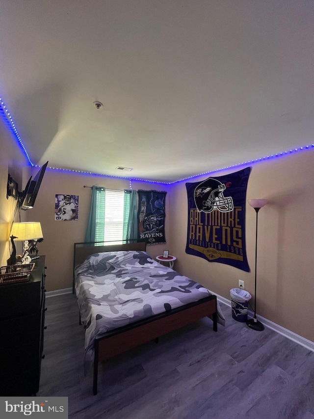 bedroom featuring baseboards and wood finished floors