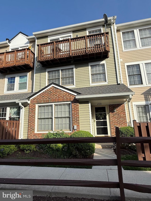 townhome / multi-family property featuring brick siding and a fenced front yard