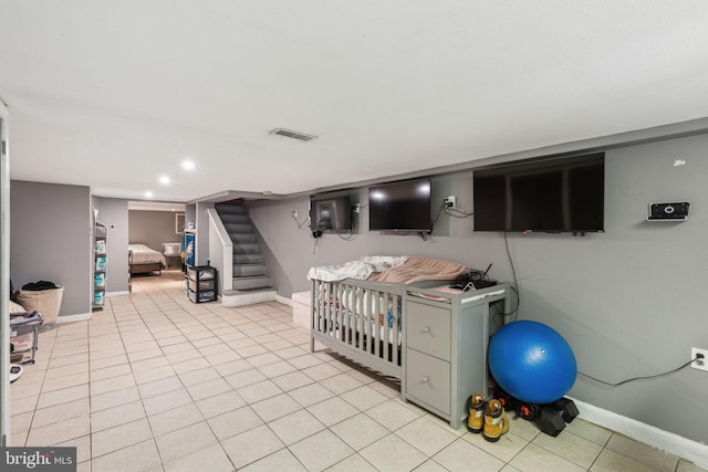 interior space with stairway, baseboards, light tile patterned floors, and visible vents