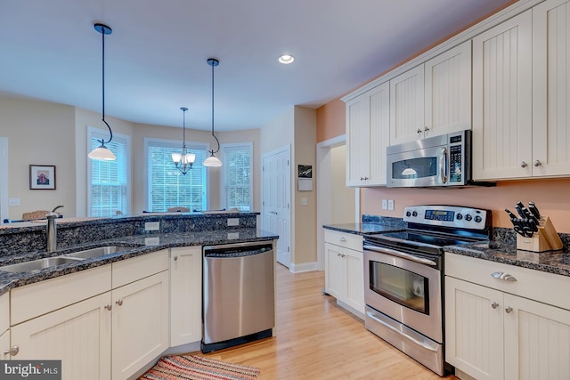 22758 Red Bay Ln, Milton, DE 19968 - kitchen featuring appliances with stainless steel finishes, a sink, light wood-style flooring, decorative light fixtures, and recessed lighting