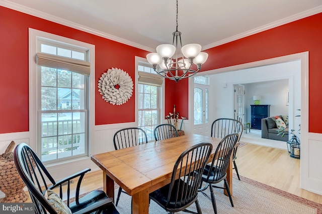 22758 Red Bay Ln, Milton, DE 19968 - dining room with light wood-type flooring, a chandelier, a wainscoted wall, and crown molding