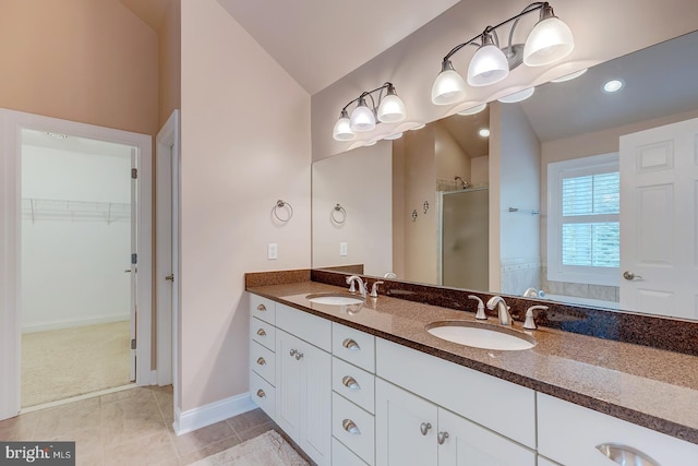 22758 Red Bay Ln, Milton, DE 19968 - bathroom with lofted ceiling, a shower stall, a walk in closet, tile patterned floors, and double vanity