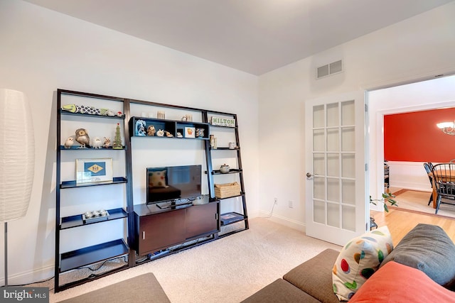 22758 Red Bay Ln, Milton, DE 19968 - living room featuring baseboards, a chandelier, french doors, and carpet floors