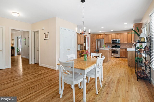 dining room with baseboards, recessed lighting, light wood-style flooring, and a notable chandelier