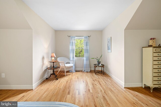 living area with baseboards and wood finished floors