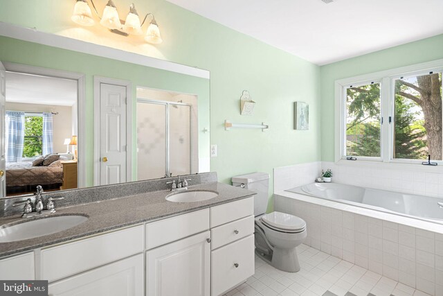 full bath with double vanity, tile patterned floors, a sink, and a stall shower