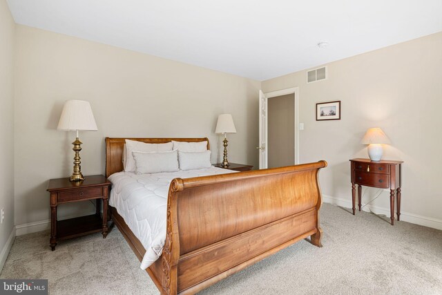bedroom with visible vents, baseboards, and light colored carpet