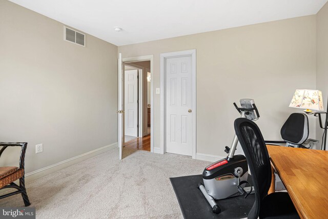 carpeted office featuring visible vents and baseboards