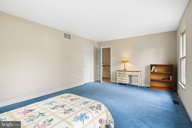 carpeted bedroom featuring baseboards and visible vents