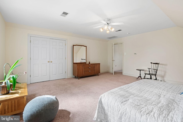 bedroom with light colored carpet, a ceiling fan, visible vents, and a closet