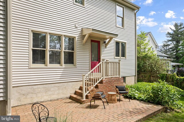 doorway to property featuring fence and a patio area