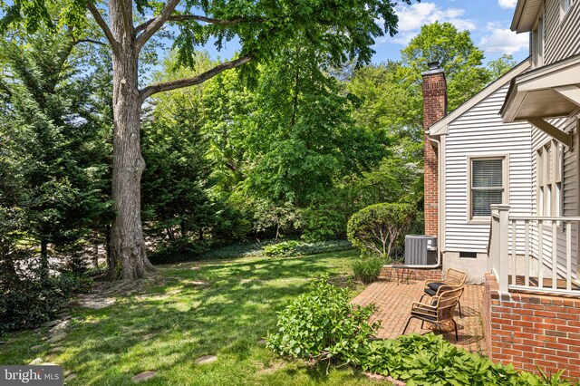 view of yard with central air condition unit and a patio