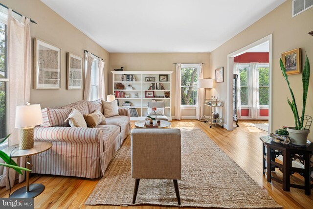 sitting room with plenty of natural light, wood finished floors, and visible vents