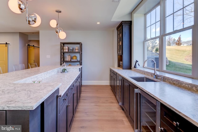 916 Prescott, Berwyn, PA 19312 - kitchen with beverage cooler, a barn door, a sink, baseboards, and light wood-style flooring