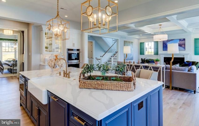 916 Prescott, Berwyn, PA 19312 - kitchen featuring stainless steel appliances, open floor plan, a sink, blue cabinets, and light wood finished floors