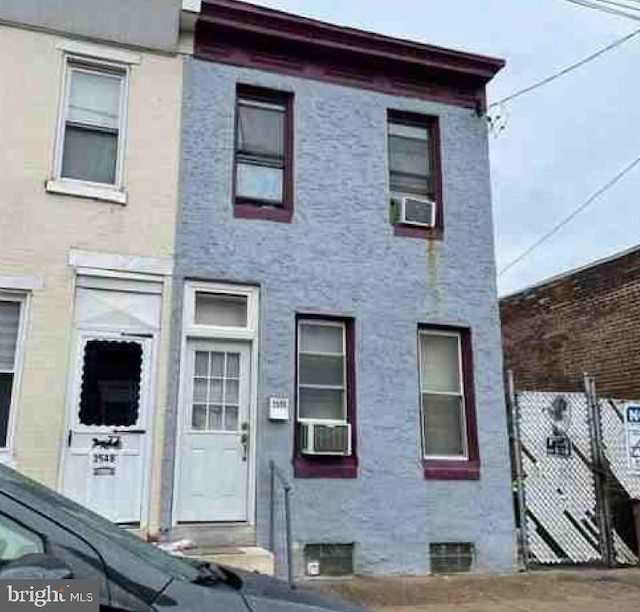3550 Emerald St, Philadelphia, PA 19134 - view of front facade featuring stucco siding, fence, and cooling unit