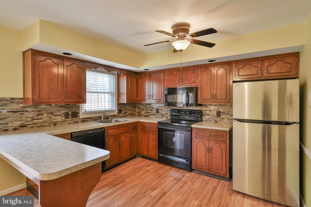 1514 Ravena St Unit D, Bethlehem, PA 18015 - kitchen featuring brown cabinets, a sink, light countertops, black appliances, and a peninsula